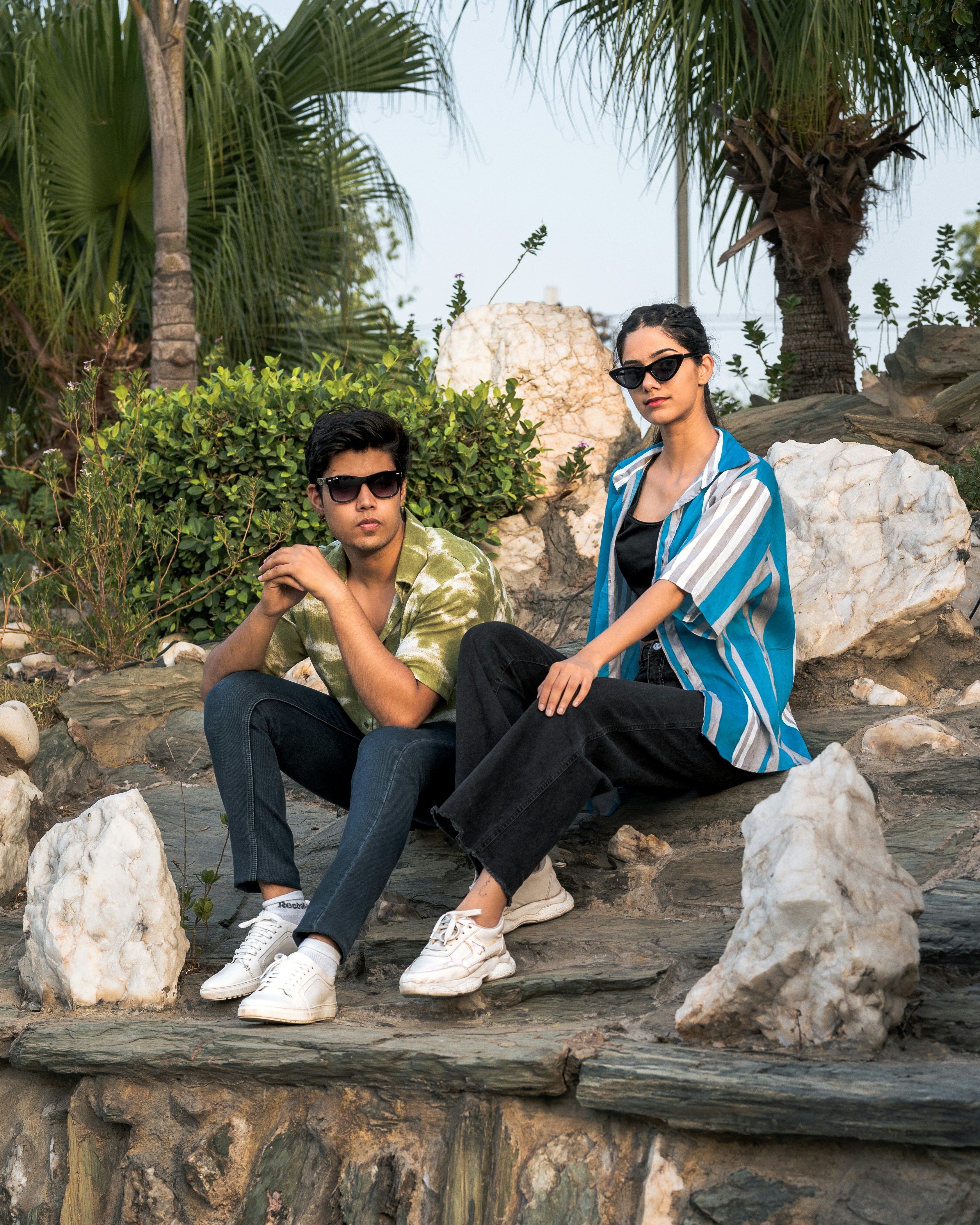 A couple of people sitting on top of a rock formation