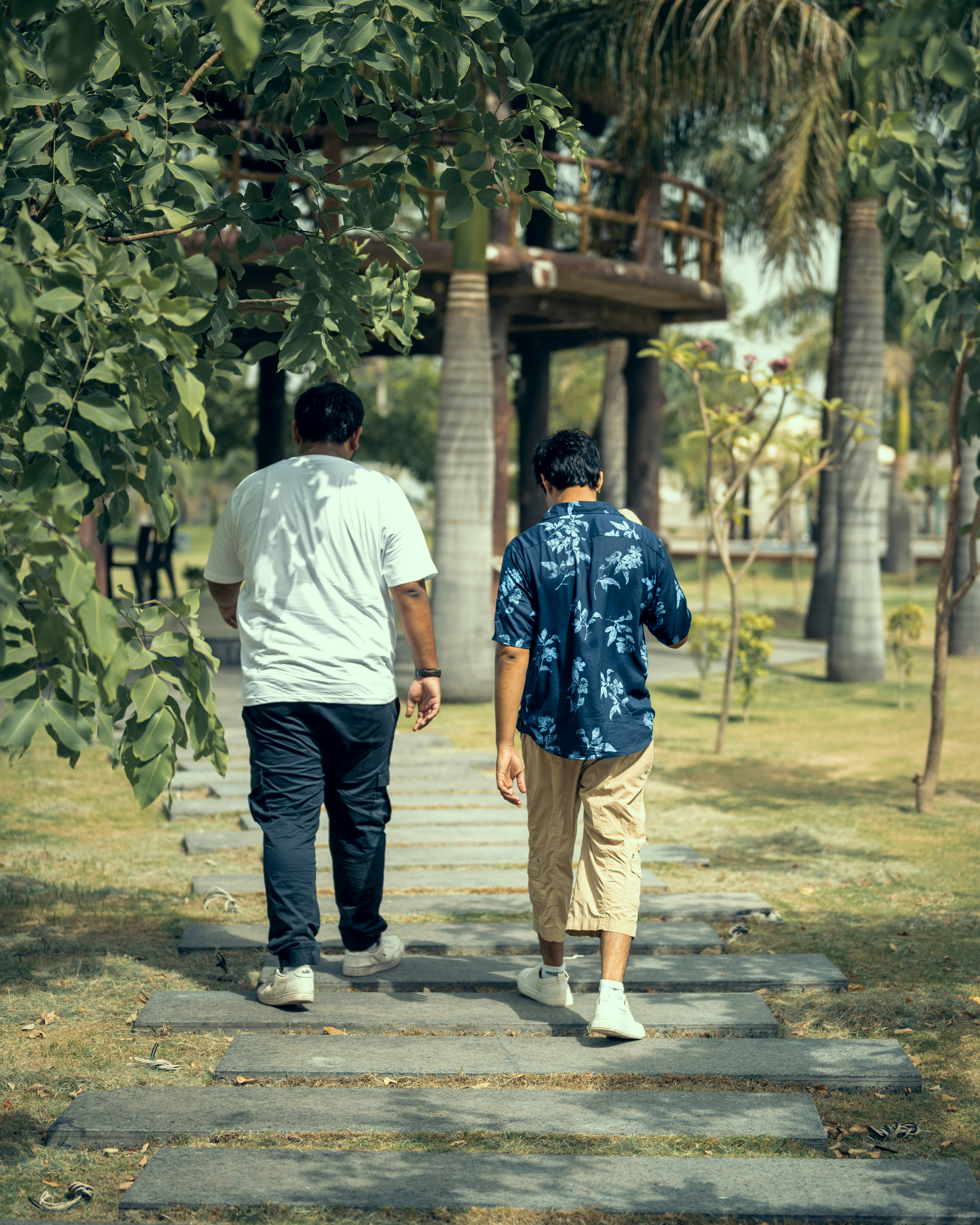 A couple of people walking down a sidewalk