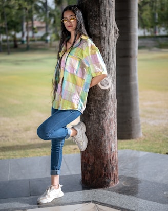 A woman leaning against a tree in a park