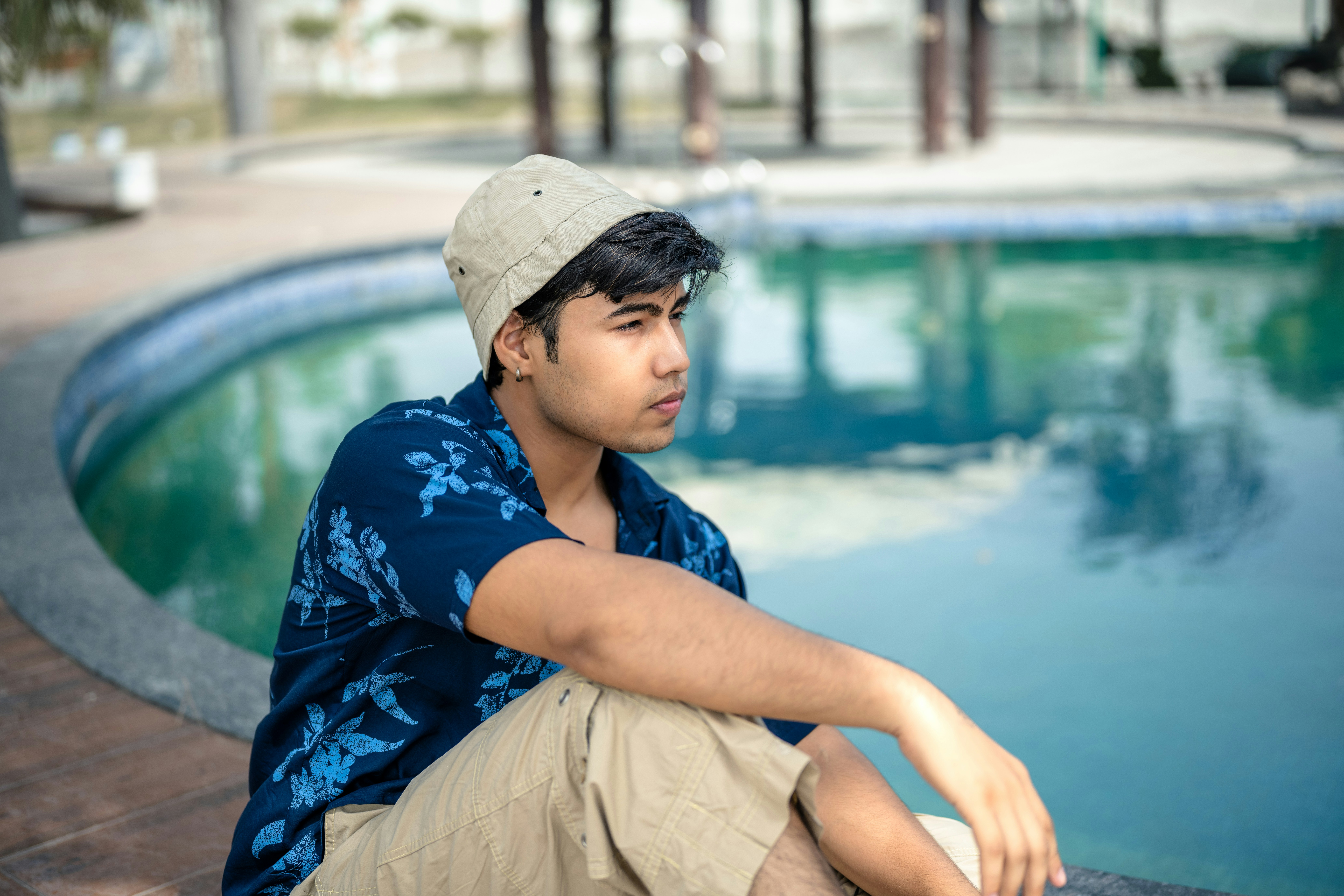 A man sitting on the edge of a swimming pool