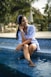 A woman sitting on the edge of a swimming pool