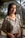 A woman with braids standing in front of a palm tree