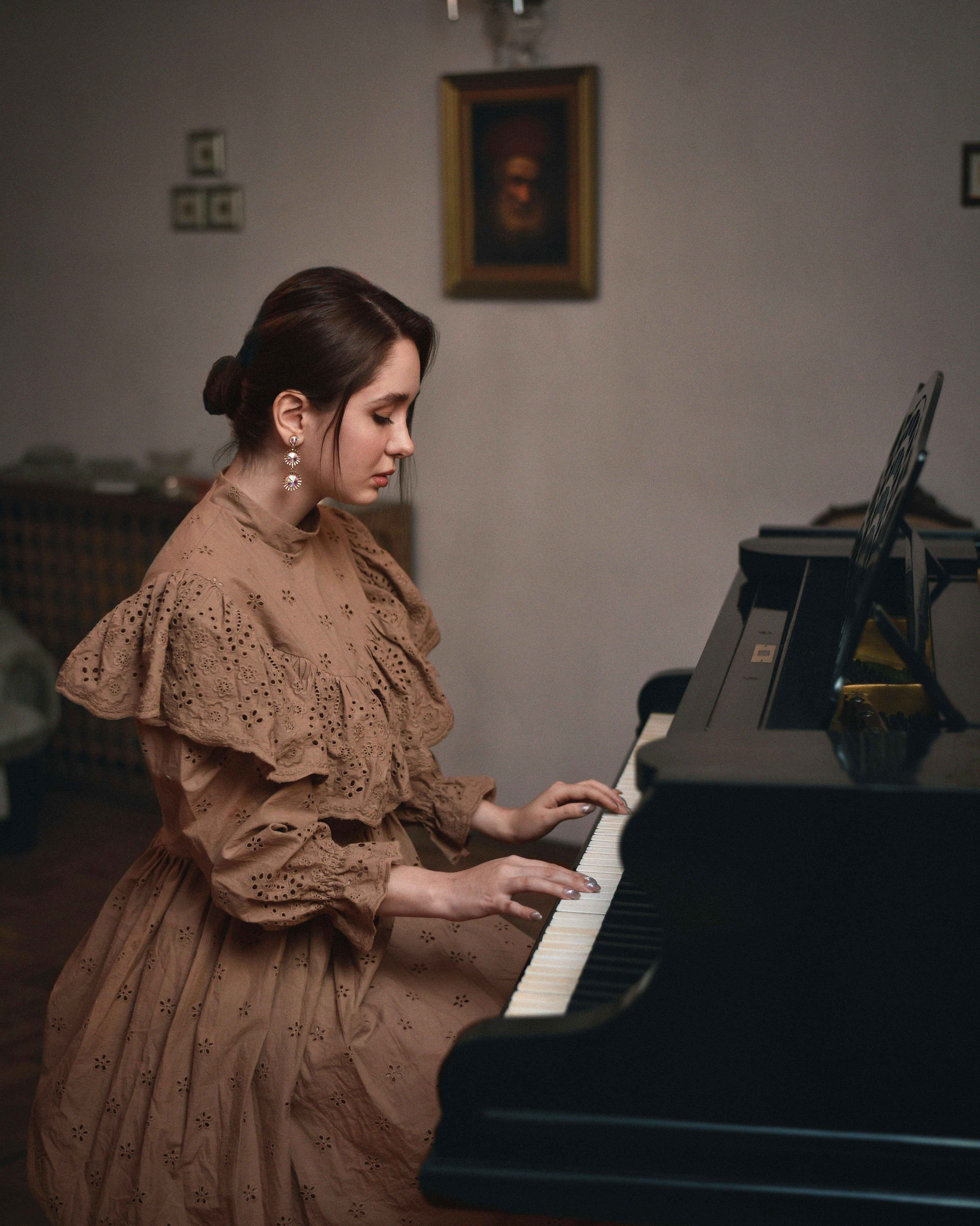 A woman in a brown dress playing a piano