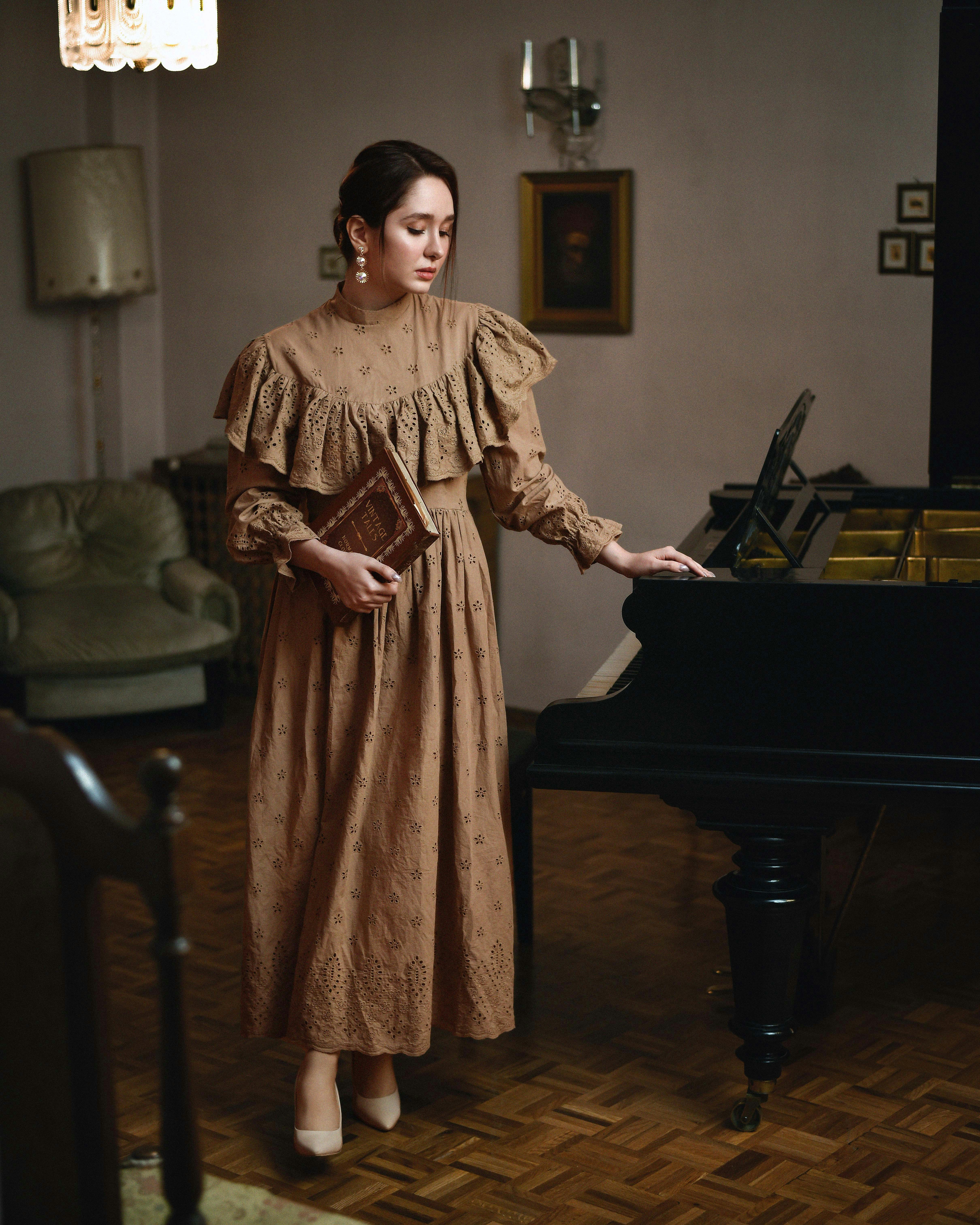 A woman standing next to a piano in a living room