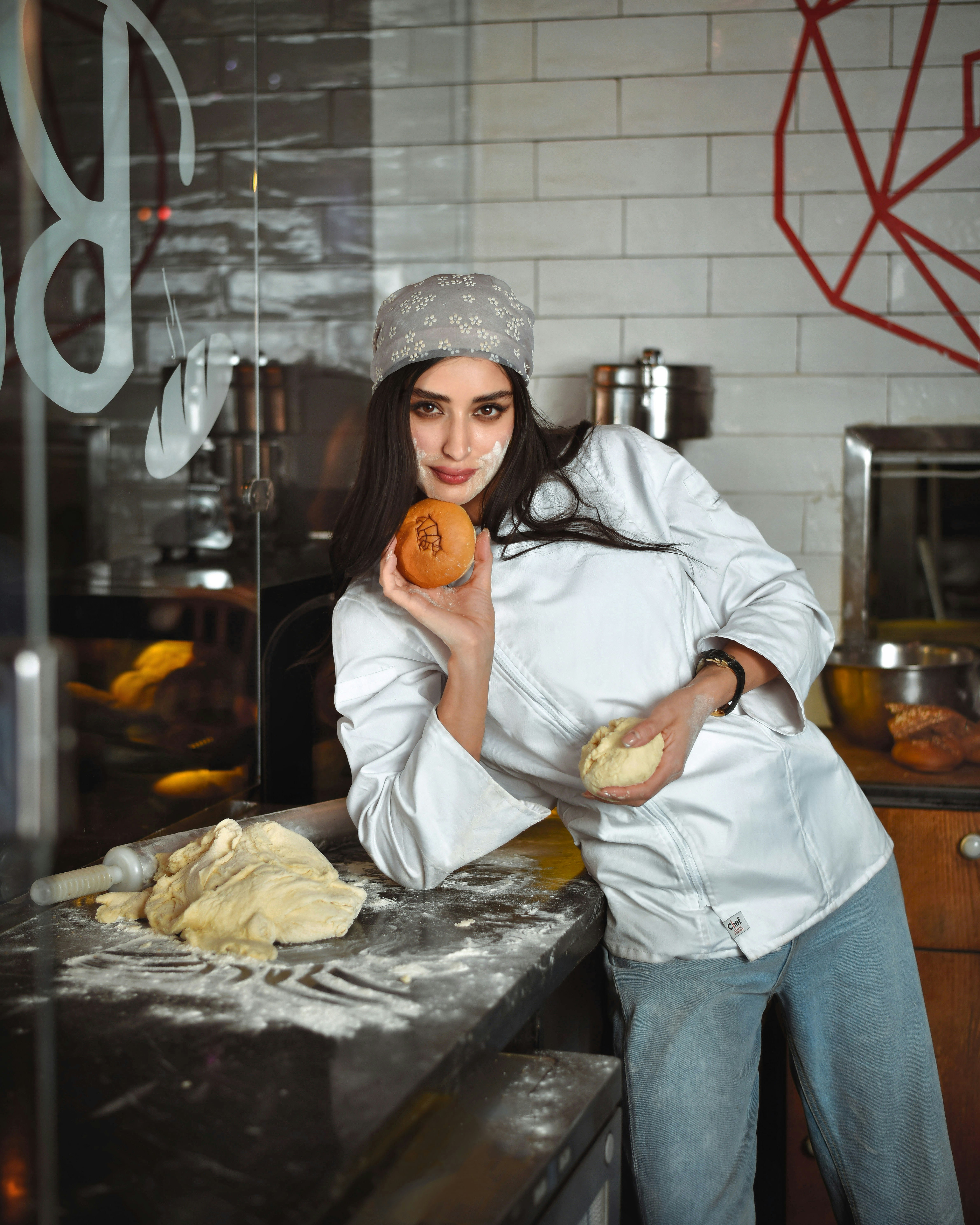 Una donna in piedi in una cucina con in mano una ciambella
