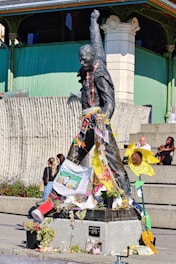 A statue of a man holding a flag in front of a building