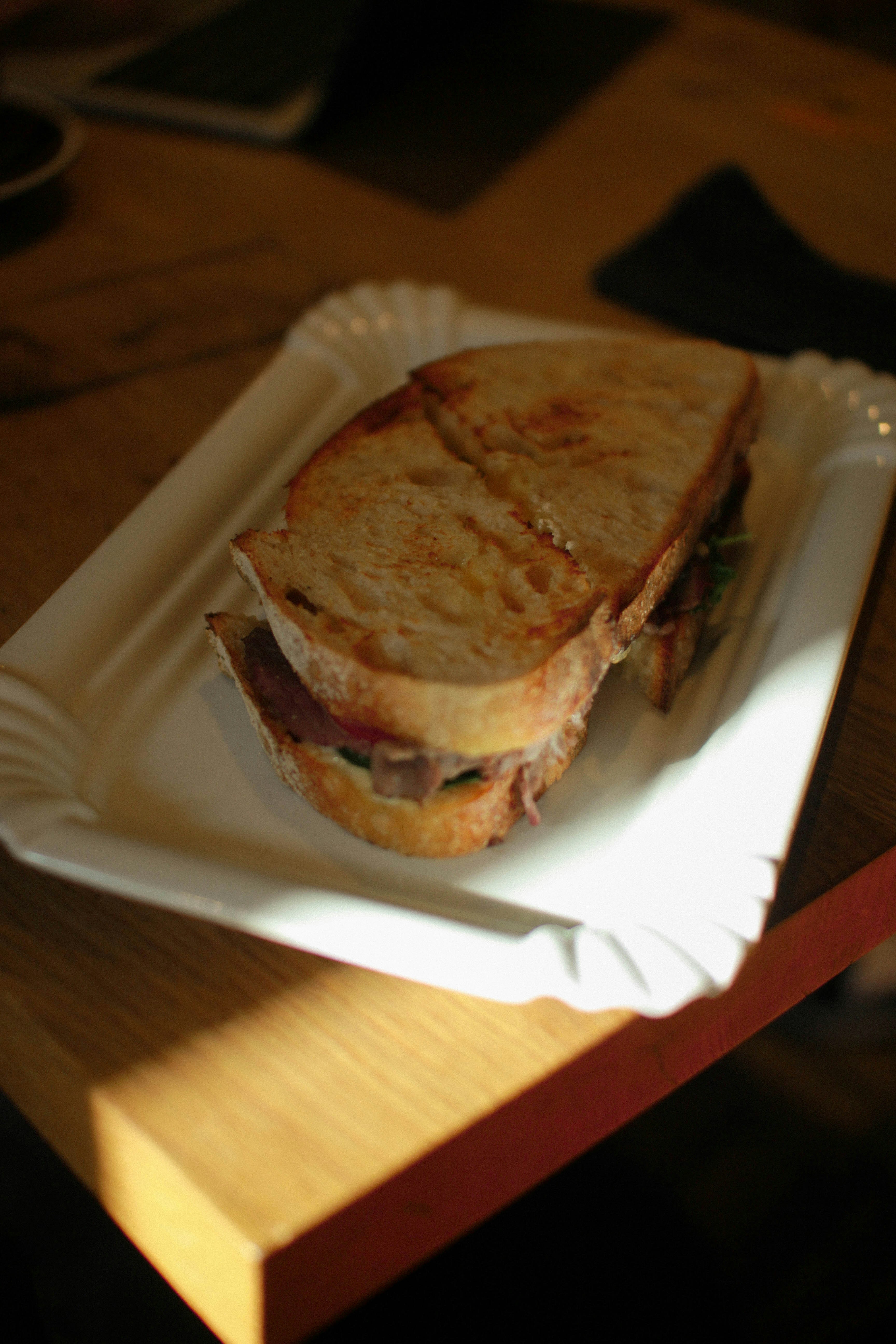 A sandwich on a paper plate on a table