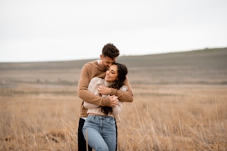 A man and a woman hugging in a field