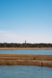 A body of water with a lighthouse in the distance
