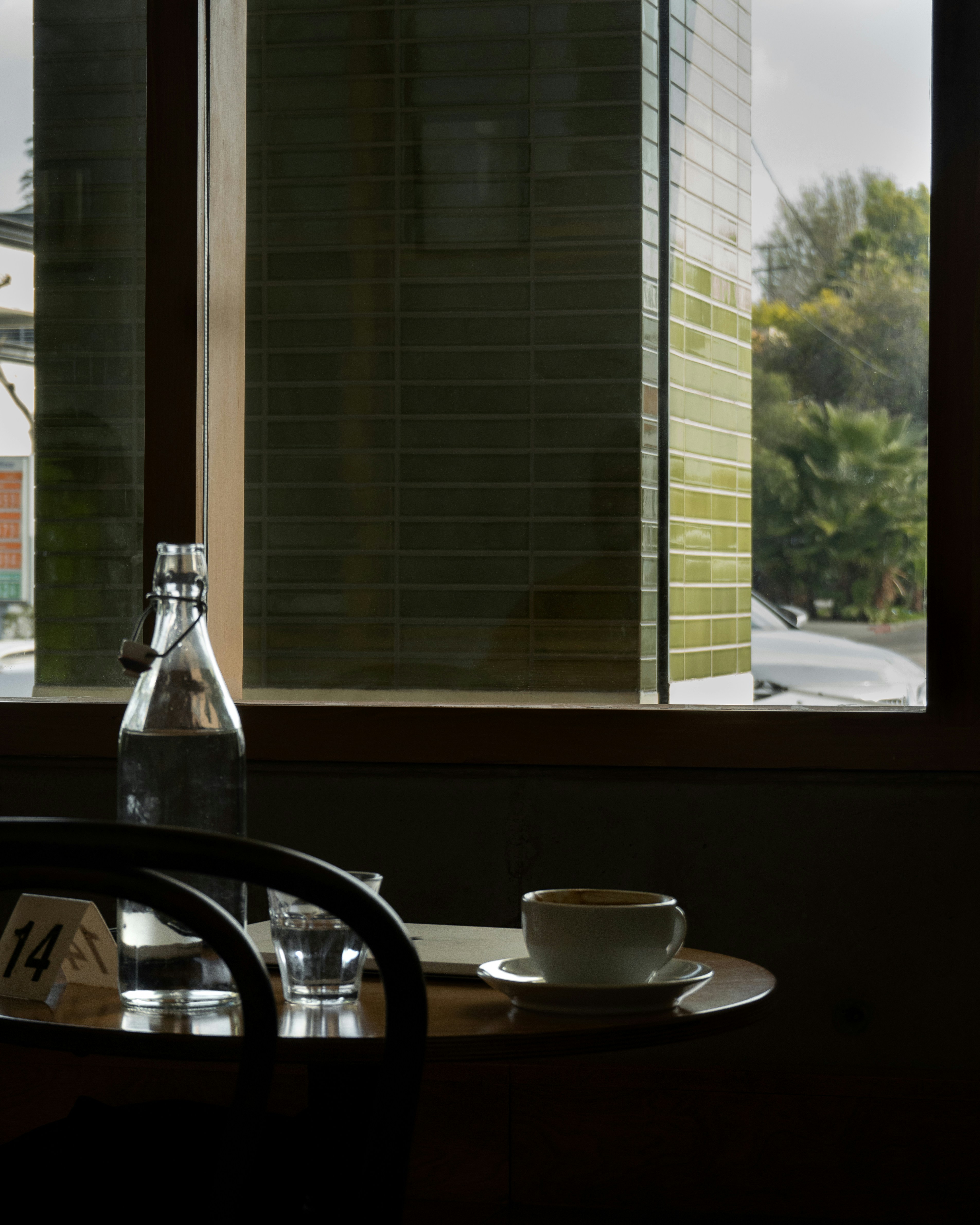 Ein Tisch mit einer Tasse und einer Untertasse vor einem Fenster