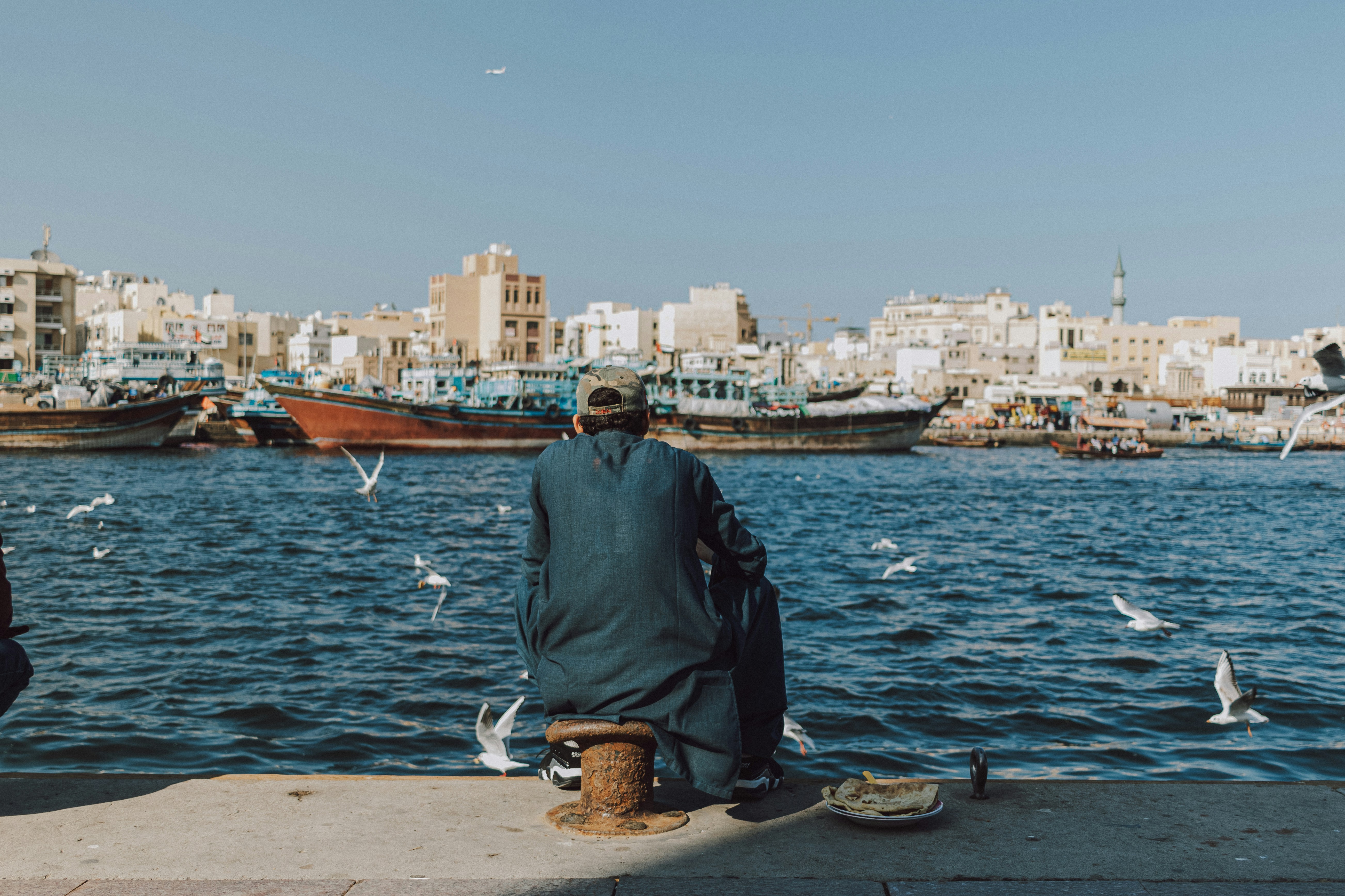 Two men sitting on a dock looking out at the water