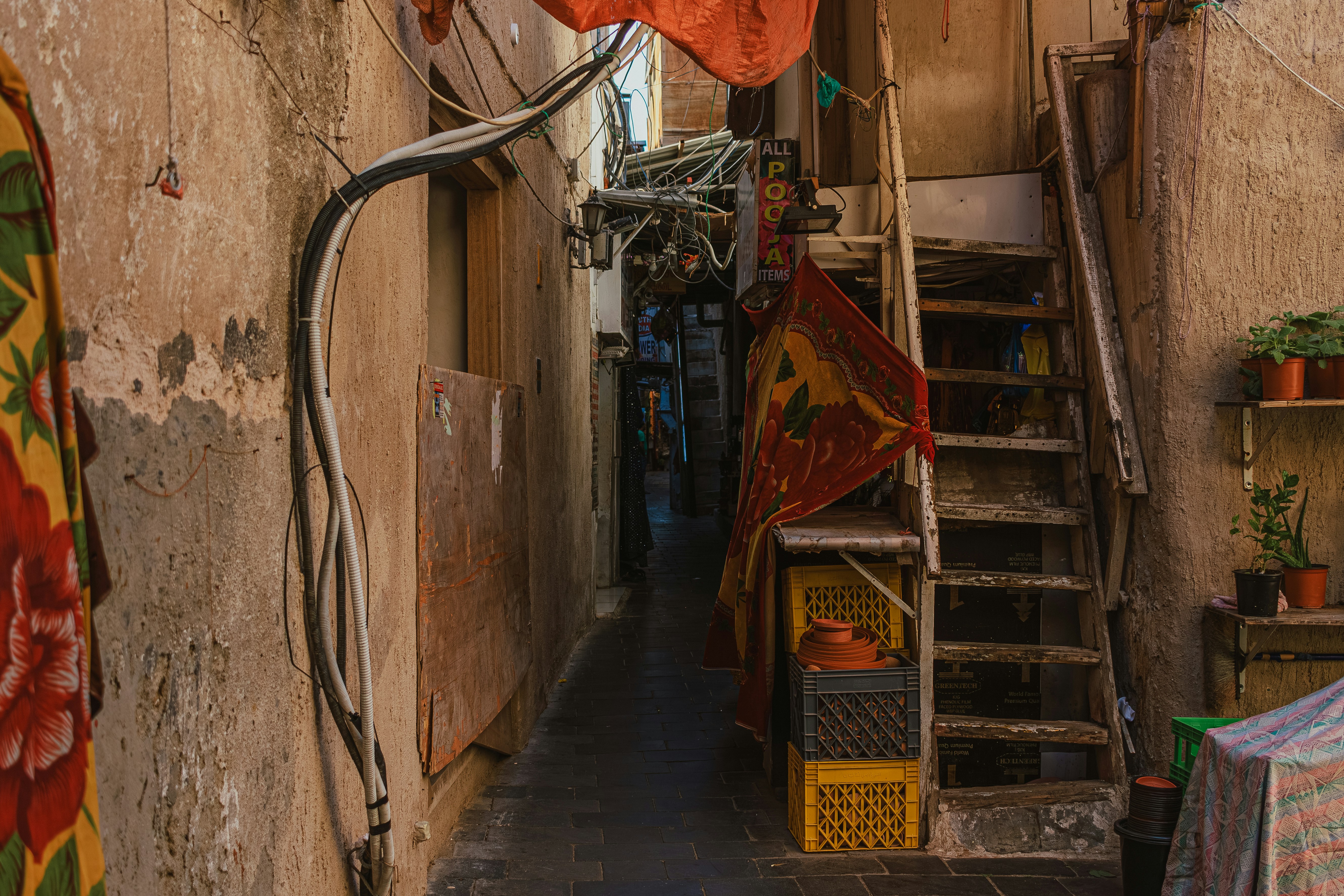 A narrow alleyway with a ladder and various items