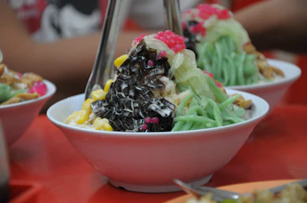A table topped with three bowls filled with food