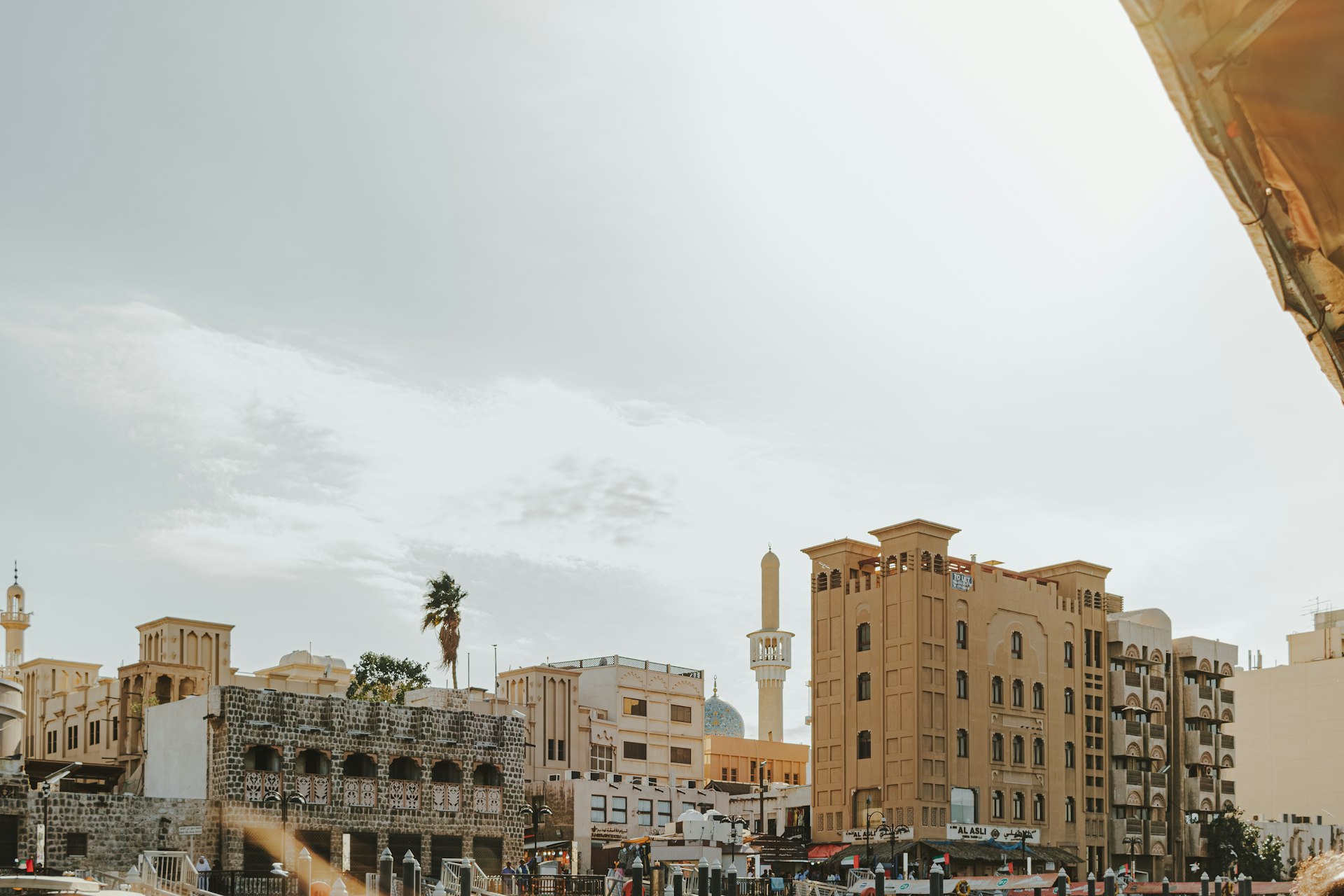 A group of people walking down a street next to tall buildings