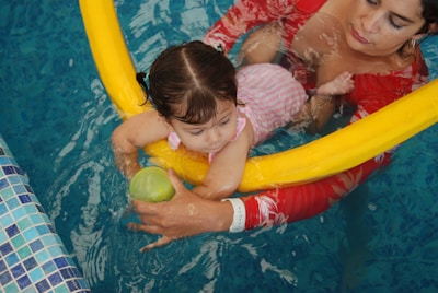 A woman holding a child in a pool