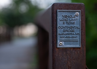 A plaque on the side of a wooden fence
