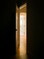 An open door in a dark room with light coming in
