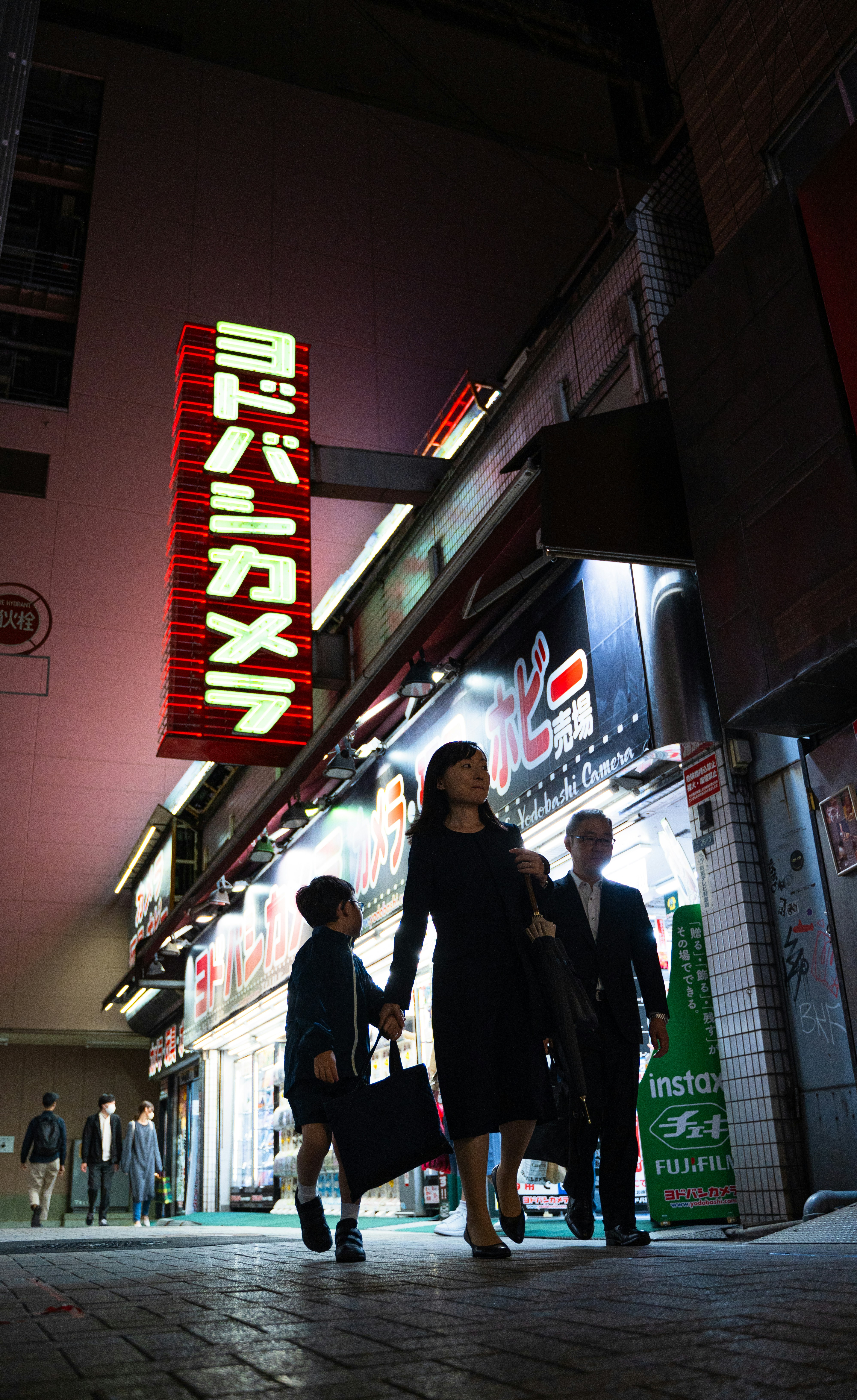A group of people walking down a street at night