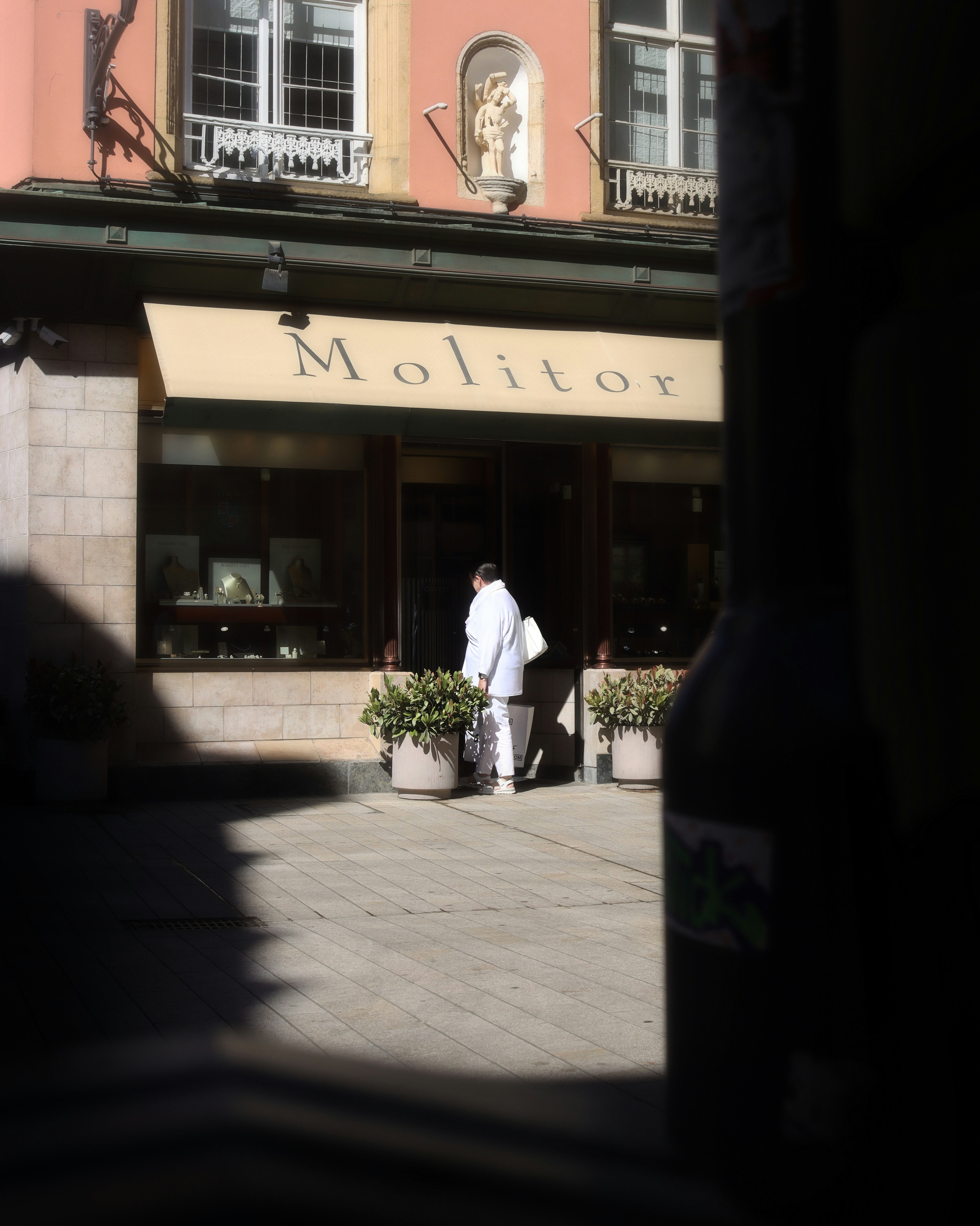 Ein Mann, der eine Straße entlanggeht, vorbei an einem hohen Gebäude