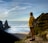 A person standing on a cliff overlooking the ocean