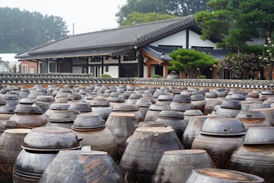 A large group of vases sitting in front of a building