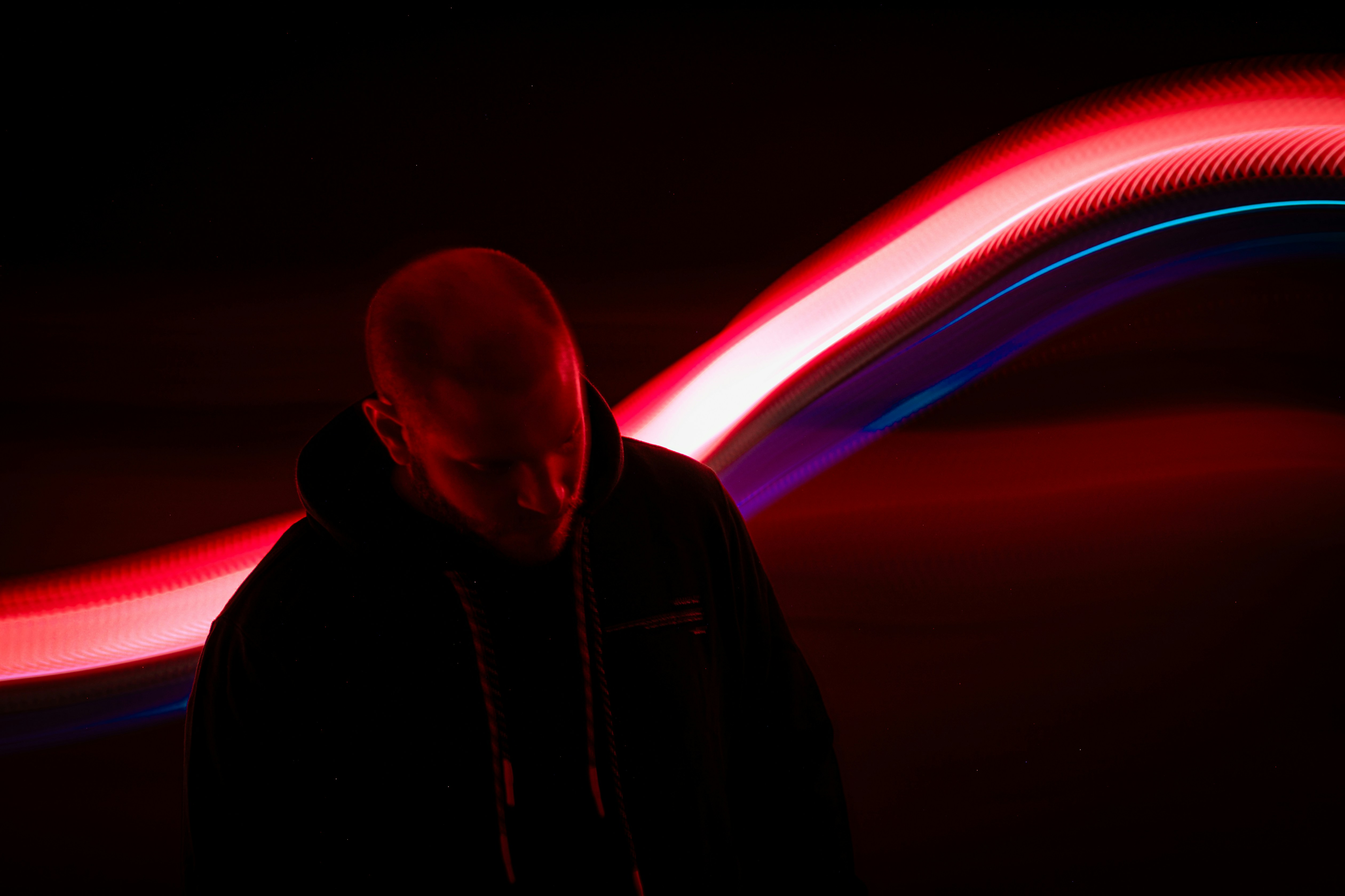 A man standing in front of a red and blue light