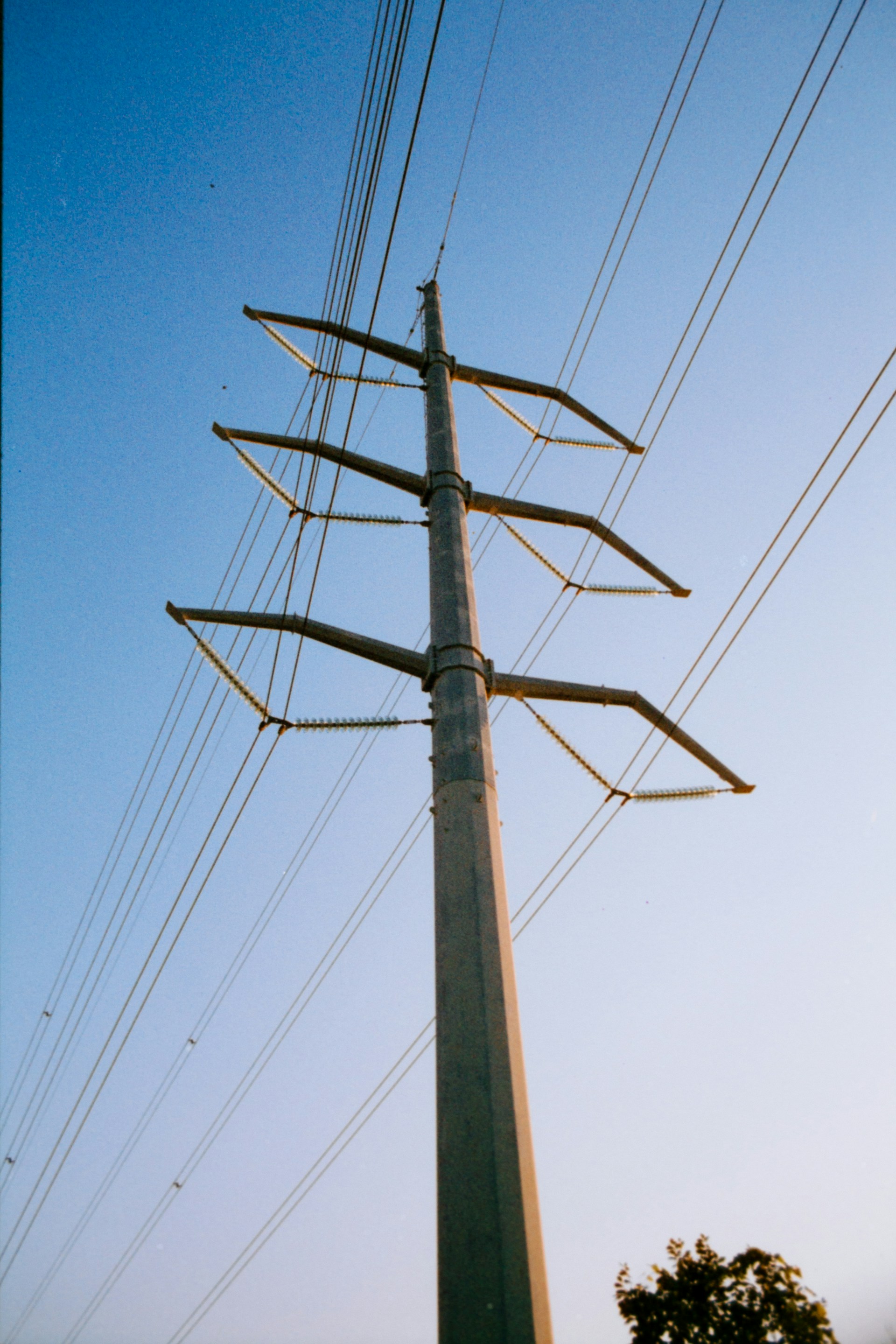 A tall pole with lots of power lines above it