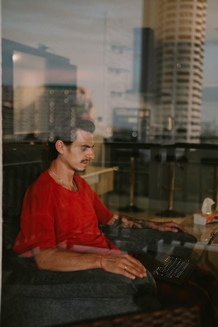 A man sitting on a couch using a laptop computer