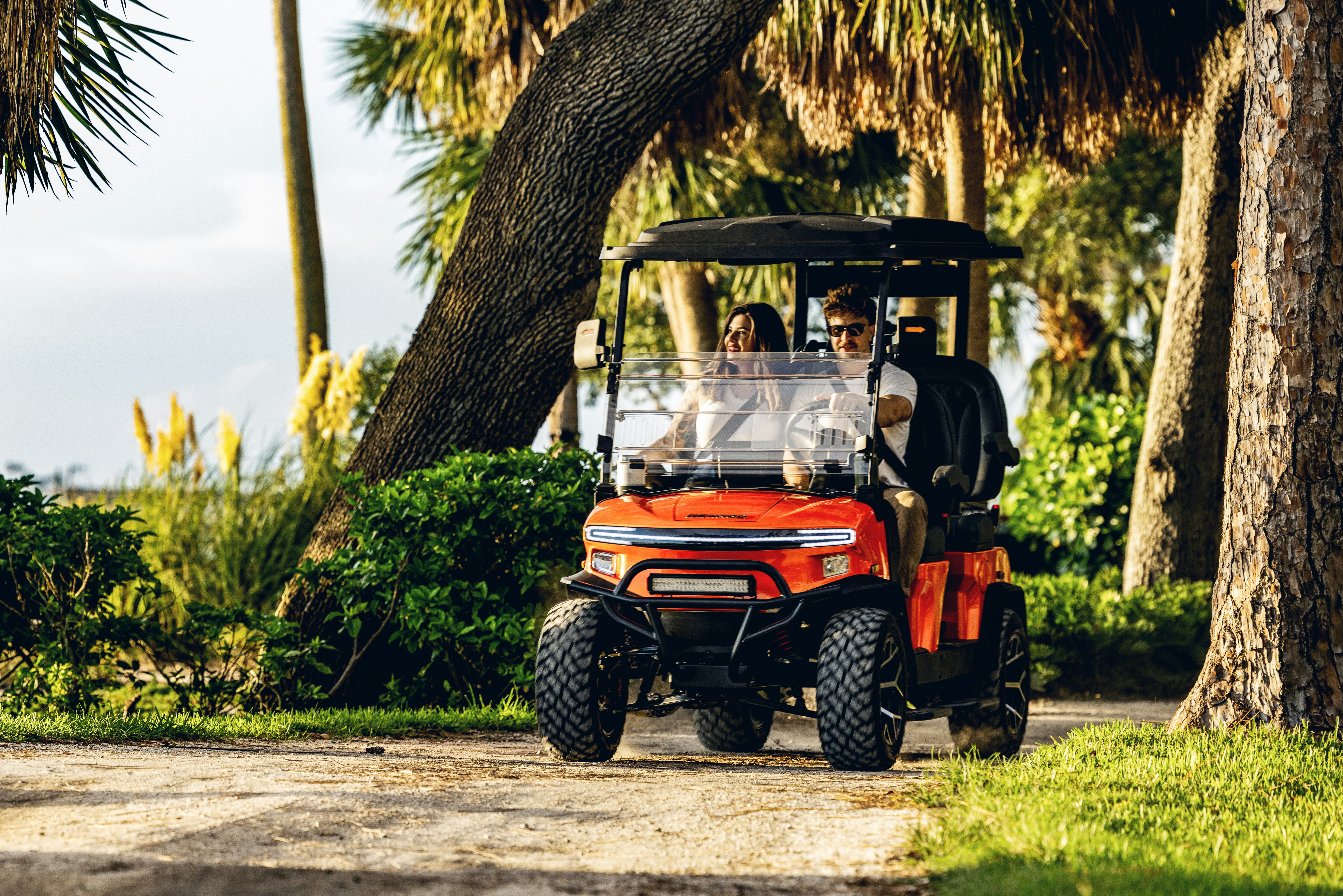 Lifted golf cart with all-terrain tires navigating a dirt trail - Golf cart tire pressure