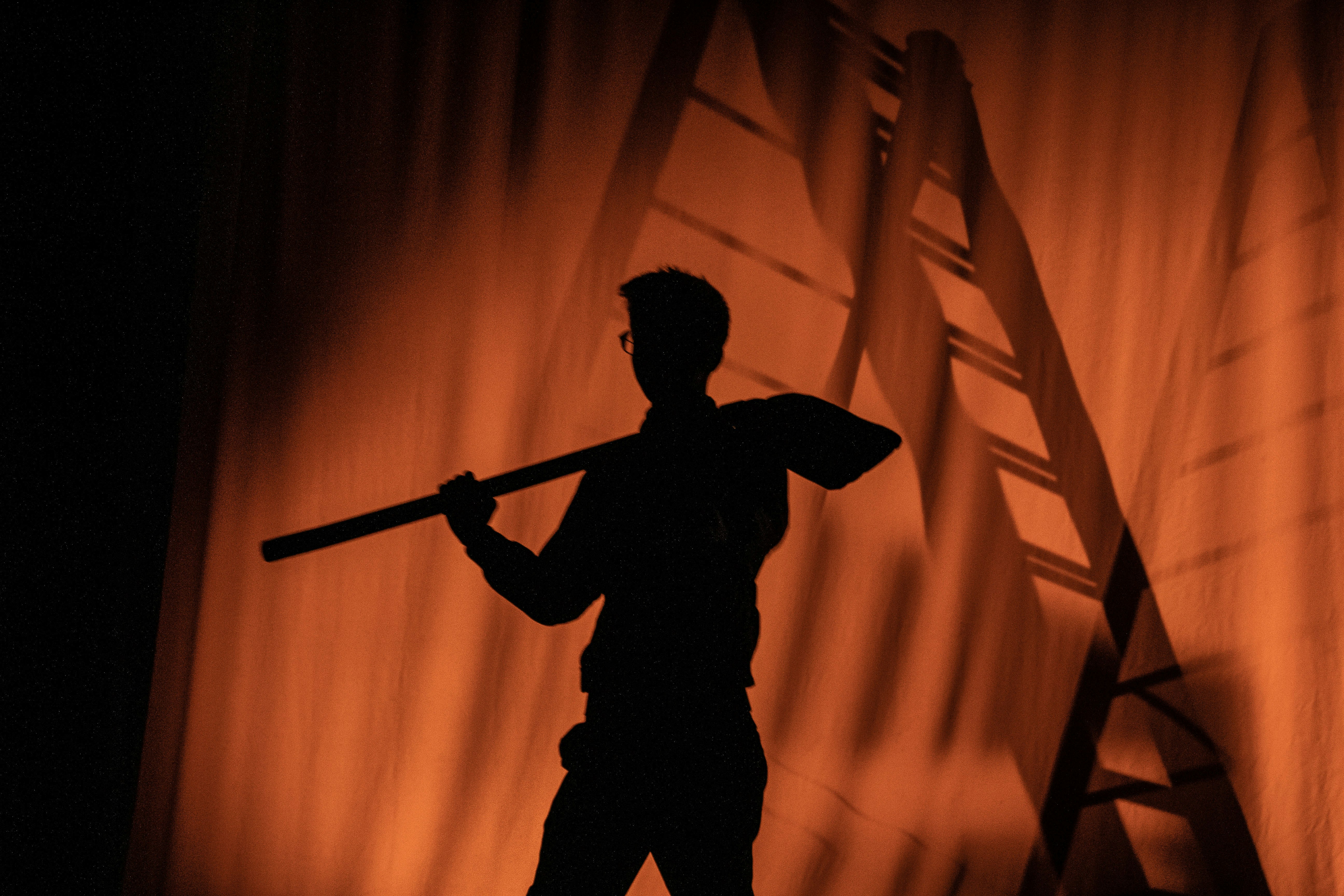 La silueta de un hombre sosteniendo un bate de béisbol