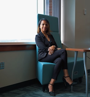 A woman sitting in a blue chair next to a table