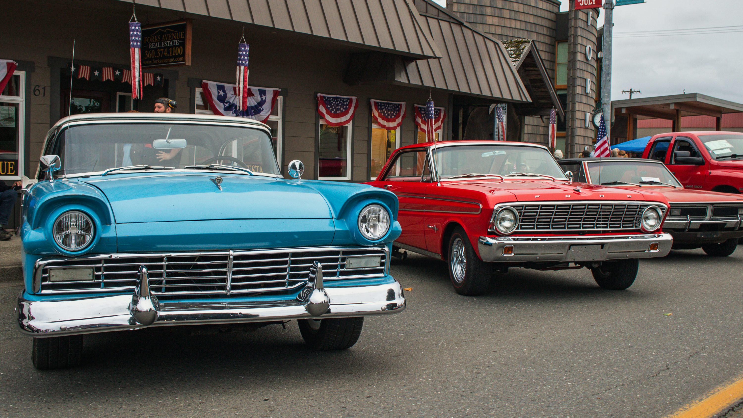 A row of classic cars parked in front of a building