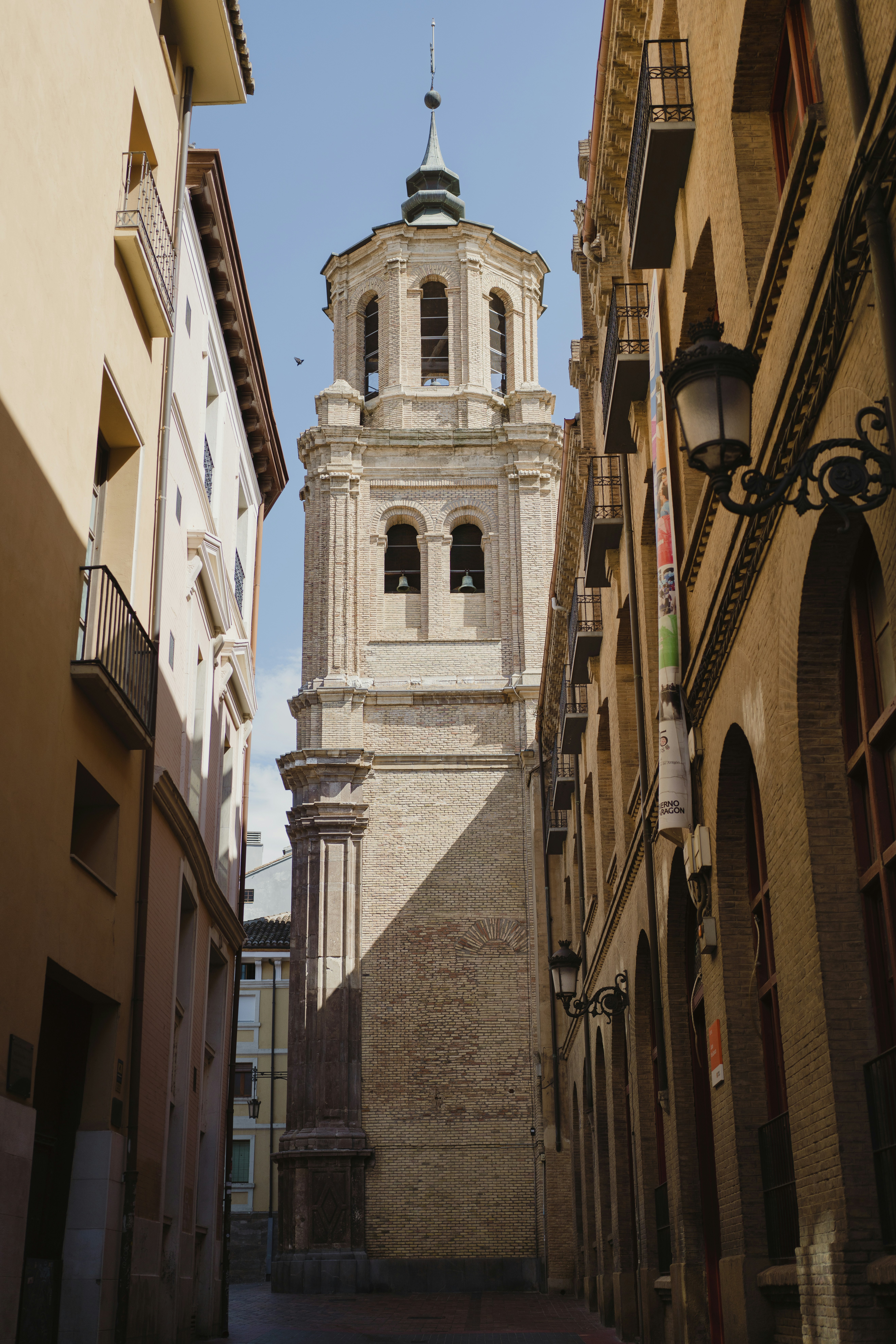 A narrow alley way with a clock tower in the background
