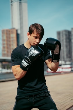 A man in black shirt and boxing gloves