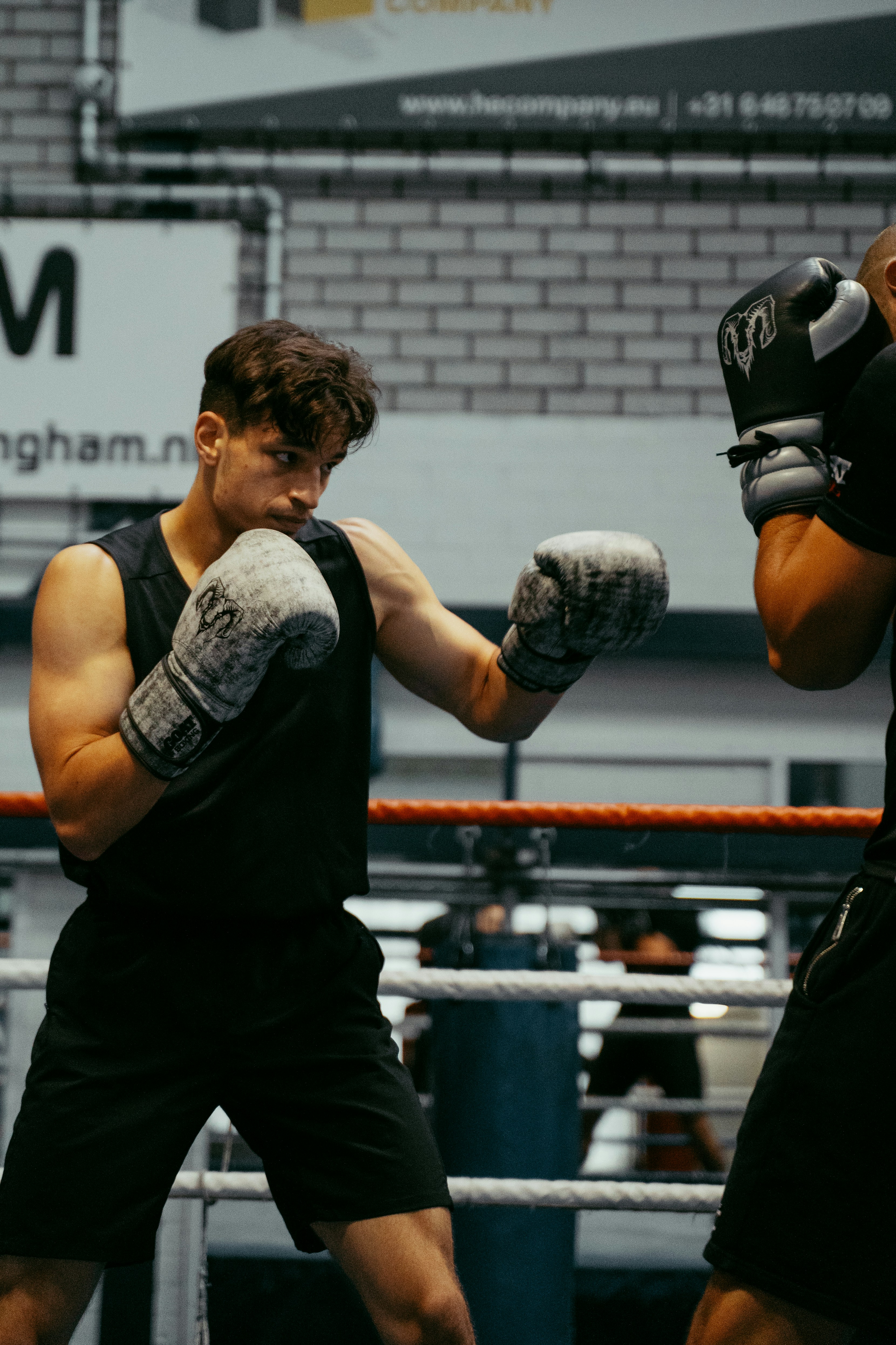 A couple of men standing next to each other in a boxing ring