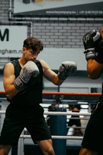 A couple of men standing next to each other in a boxing ring