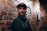 A man with a beard standing in front of a brick wall