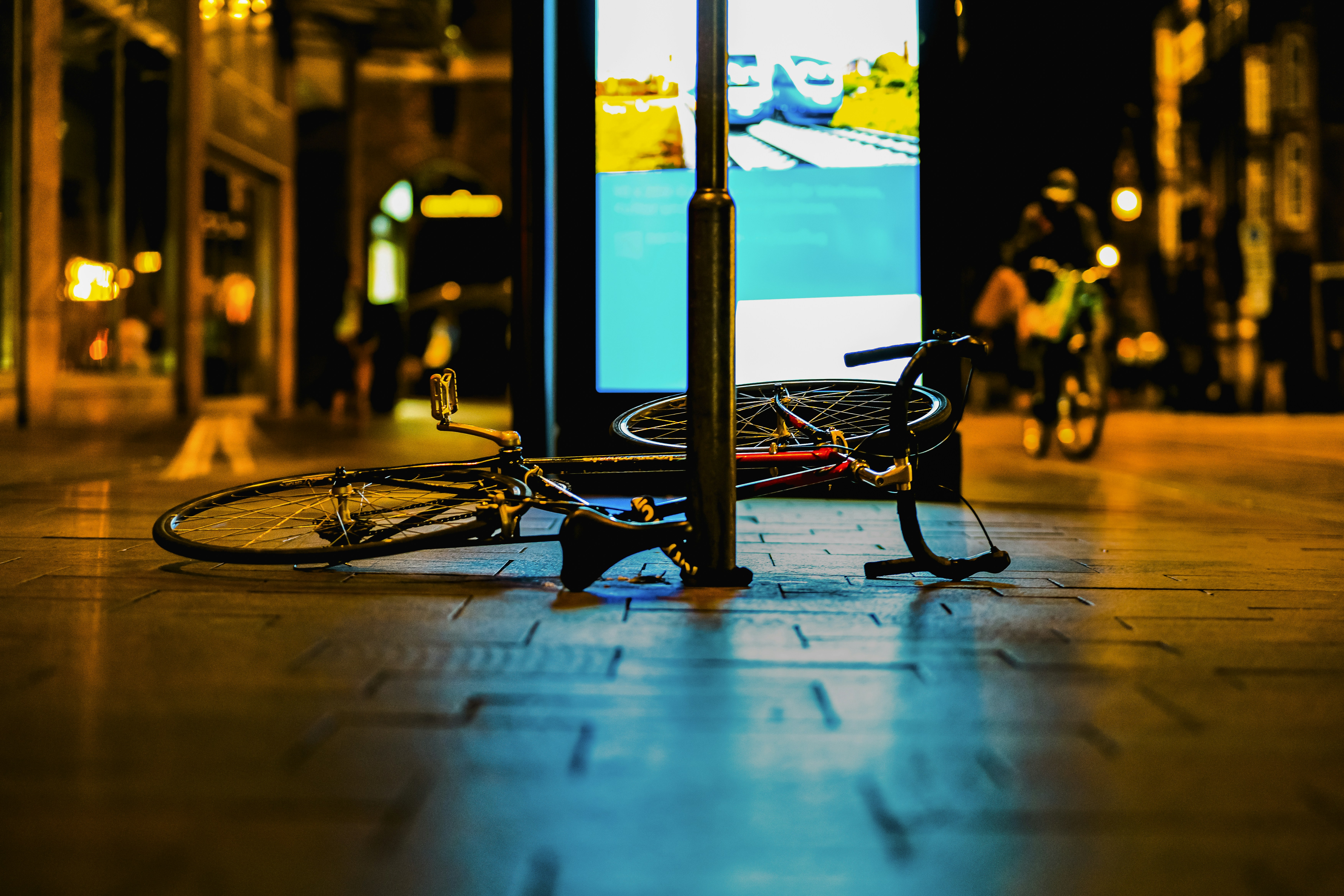 A bicycle leaning against a pole on a city street