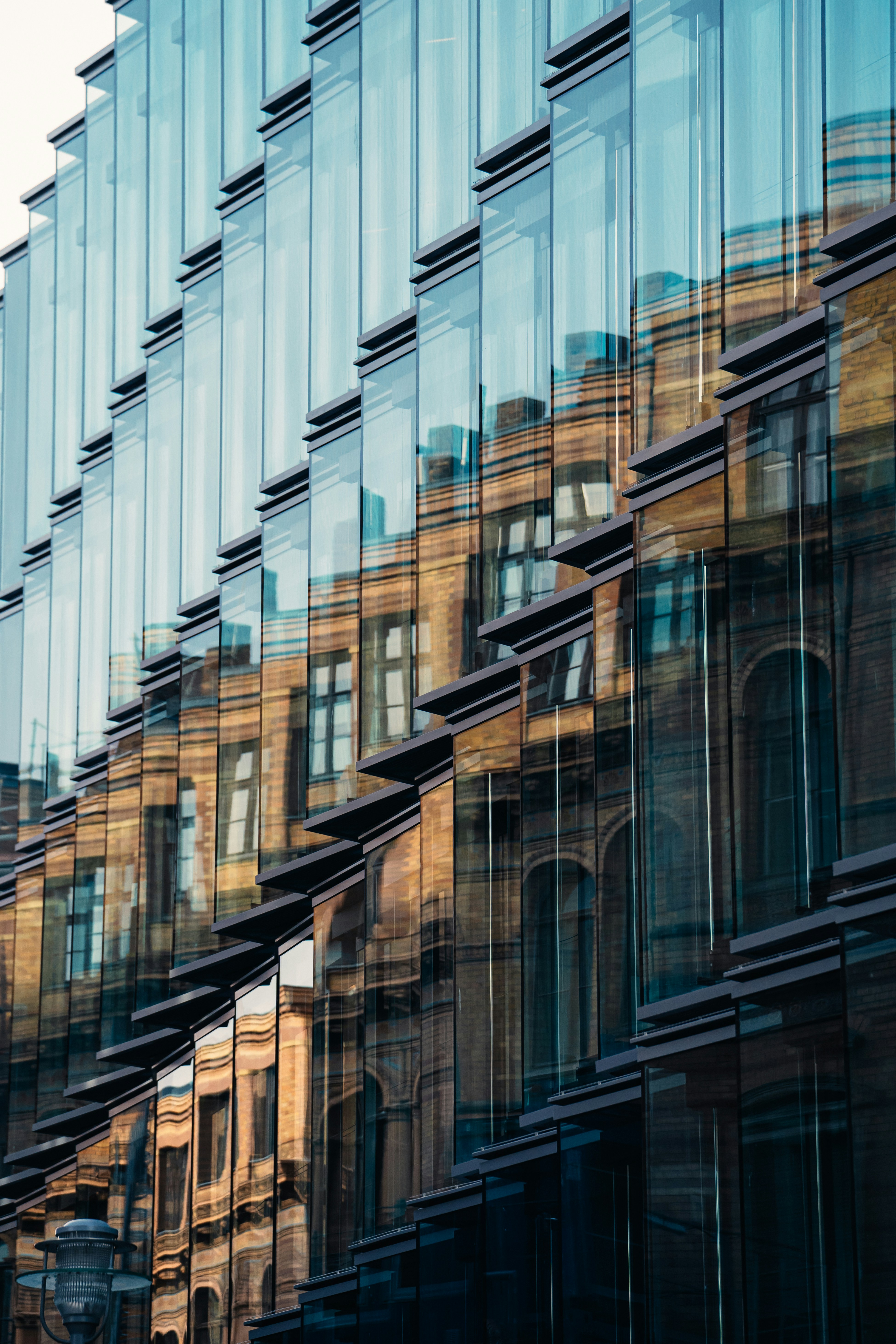 A very tall building with many windows reflecting the sky