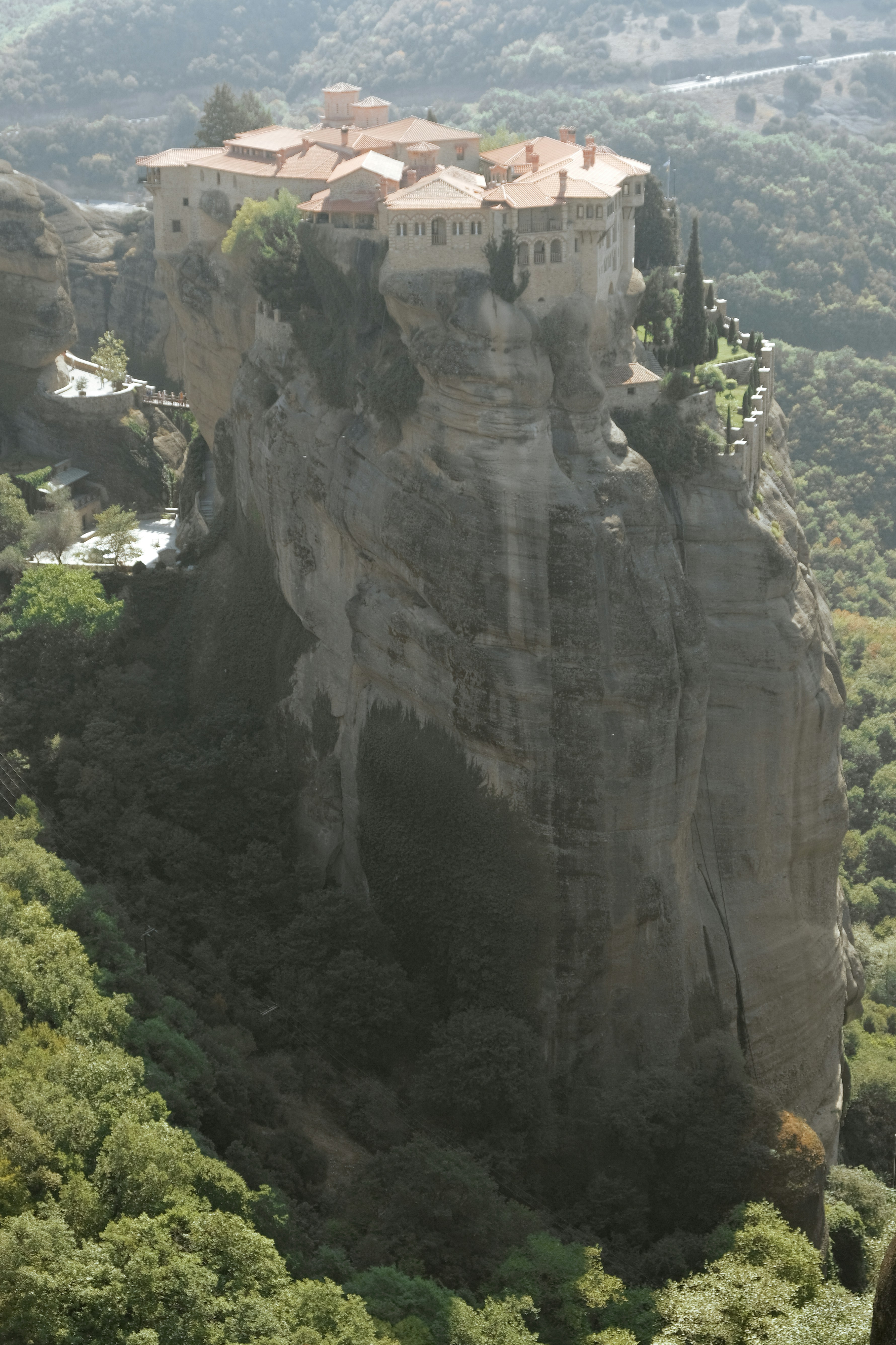 Bhutanese monastery perched on a cliff face surrounded by pine forest and mountain mist — spiritual, serene, ancient