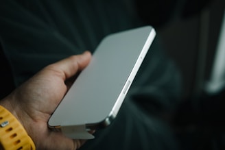 A person holding a white device in their hand