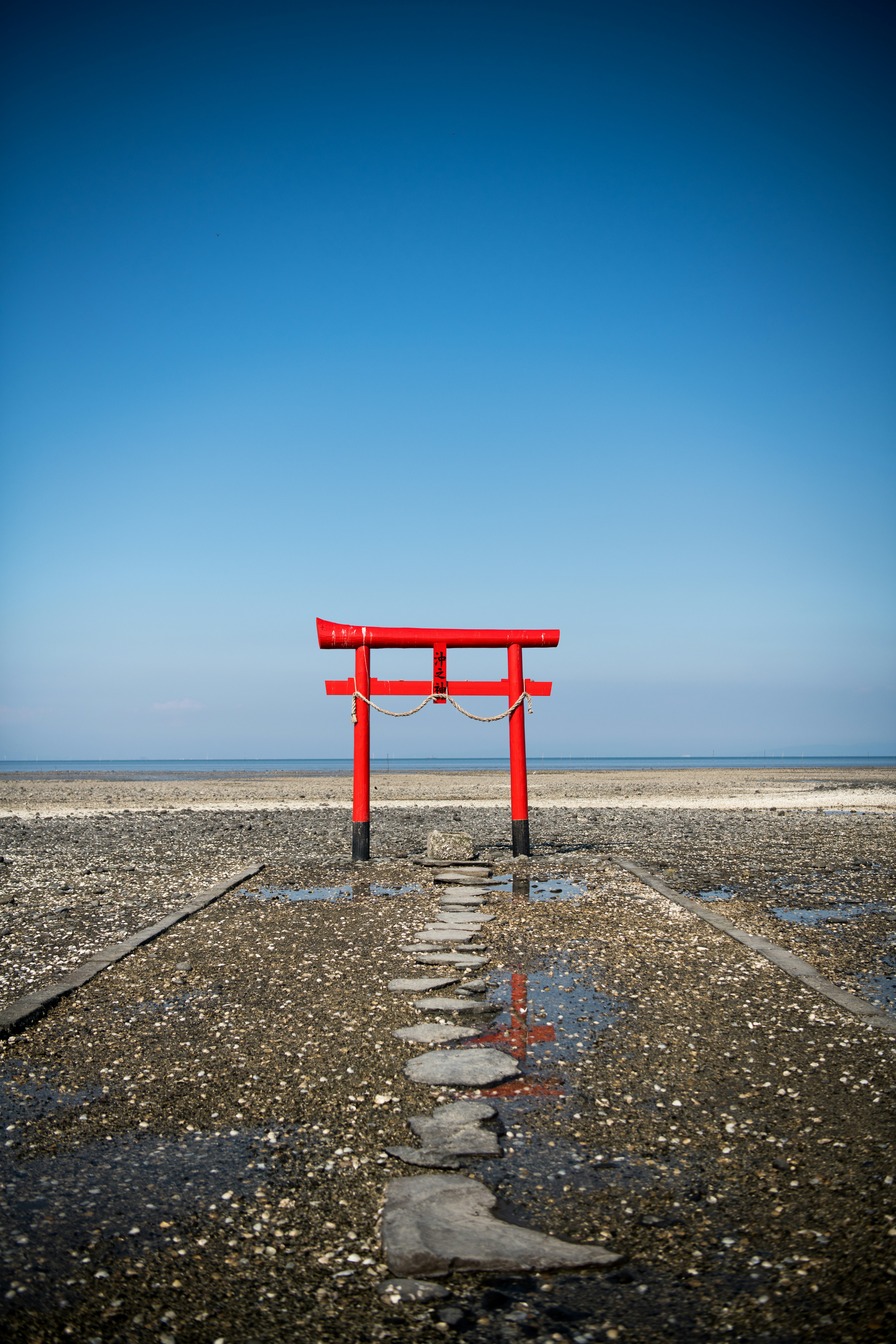 A red chair sitting on top of a wet beach