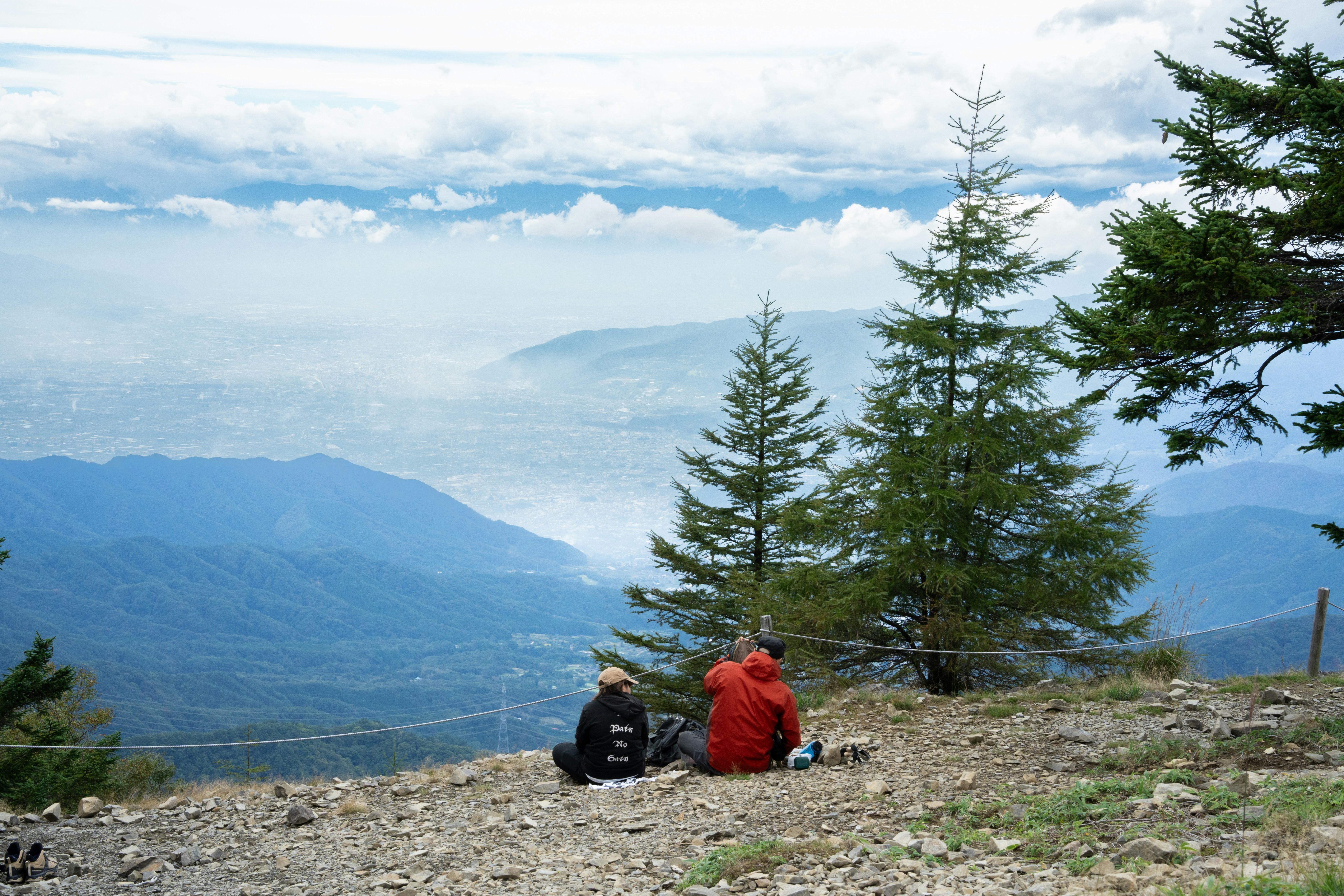 A couple of people sitting on top of a mountain