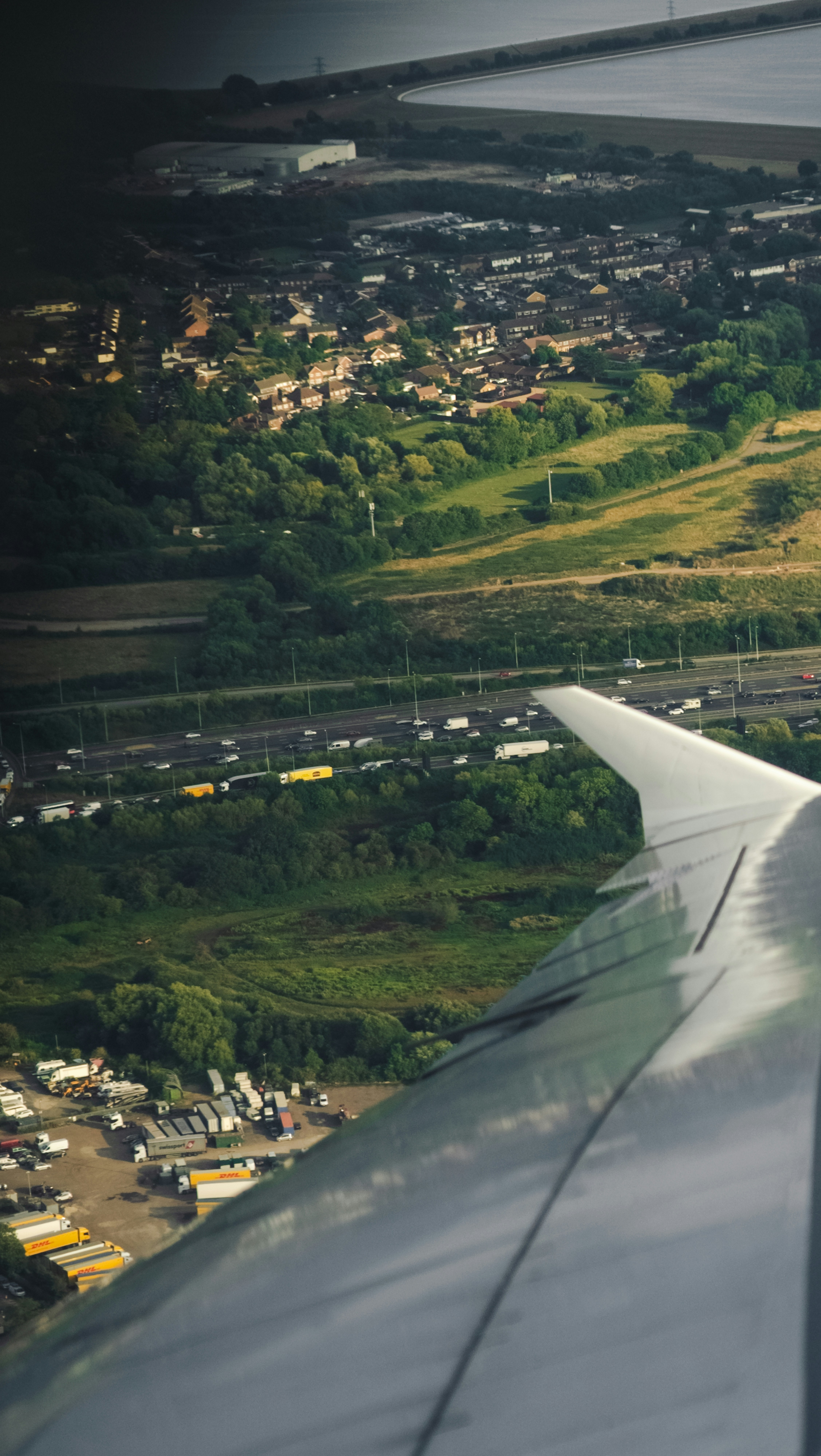 The wing of an airplane flying over a city
