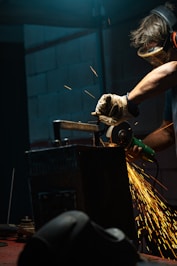 A man working with a grinder in a factory