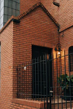 A red brick building with a black gate