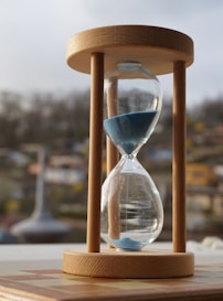 An hourglass sitting on top of a wooden table