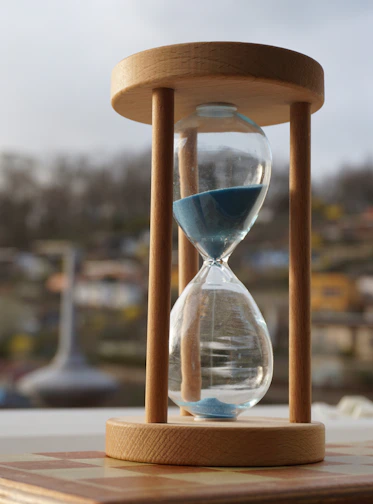An hourglass sitting on top of a wooden table