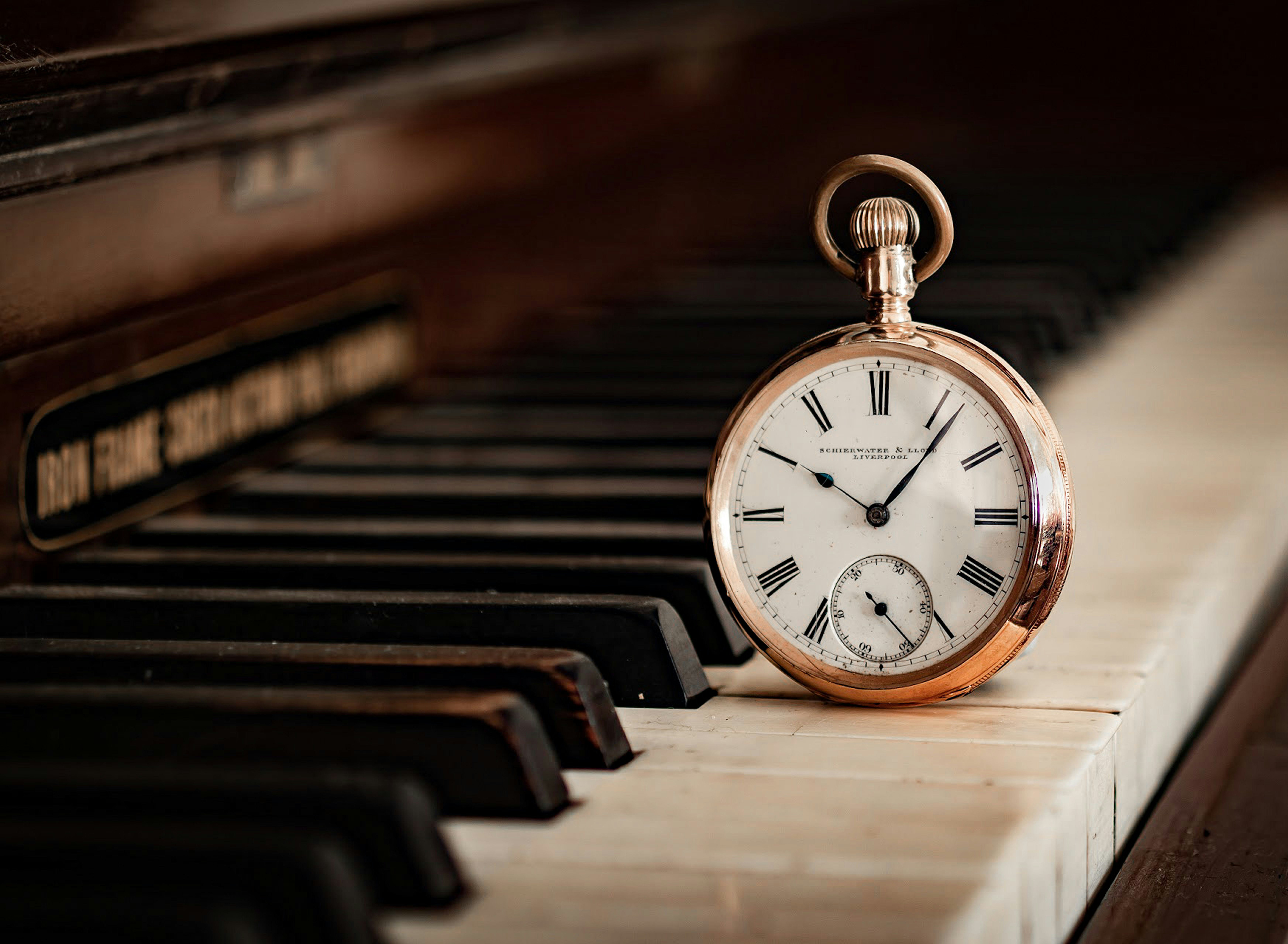 A pocket watch sitting on top of a piano