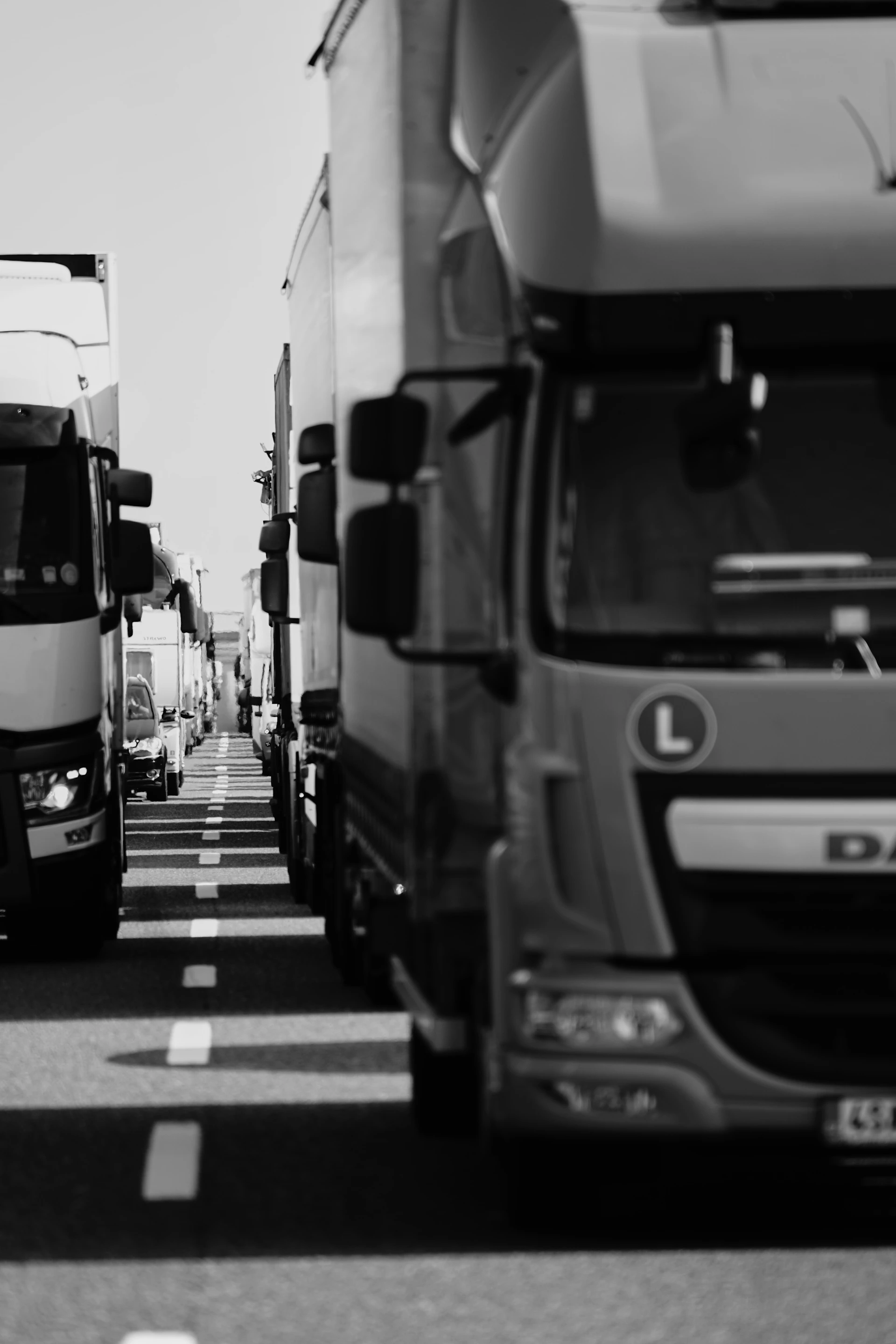A black and white photo of a line of trucks
